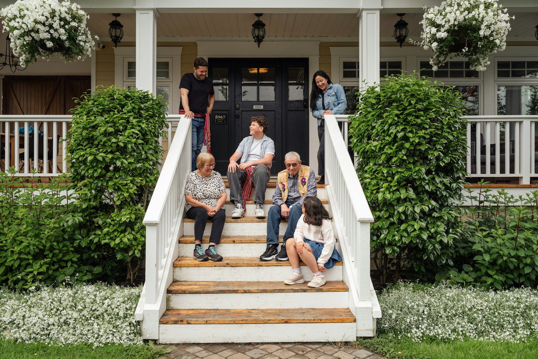 A family sitting on the front steps of a house