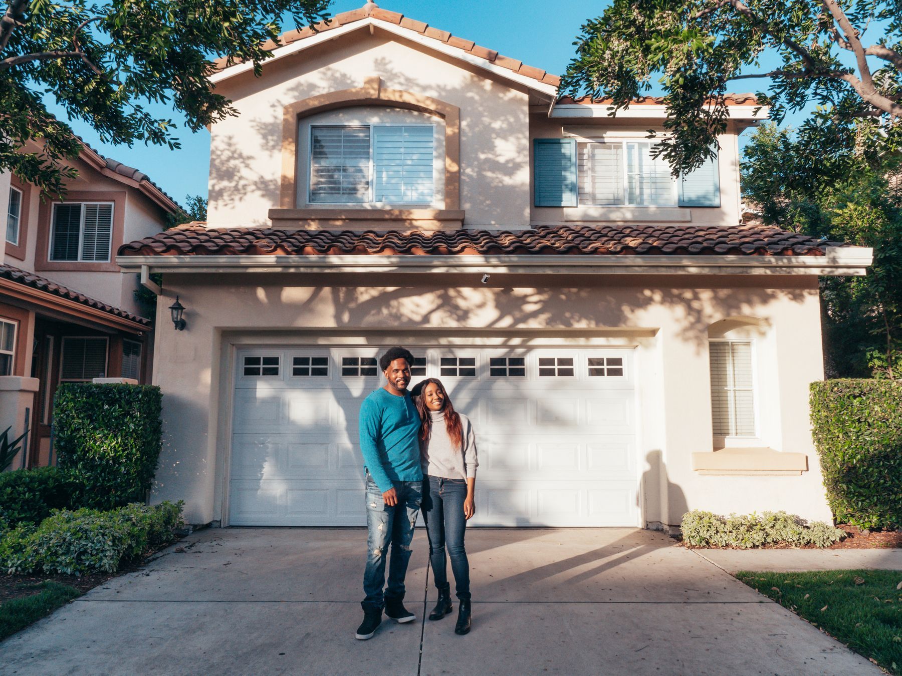 A couple standing in the driveway of their home